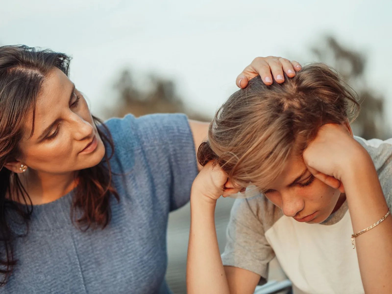 Mother offering support to her discouraged teenage son