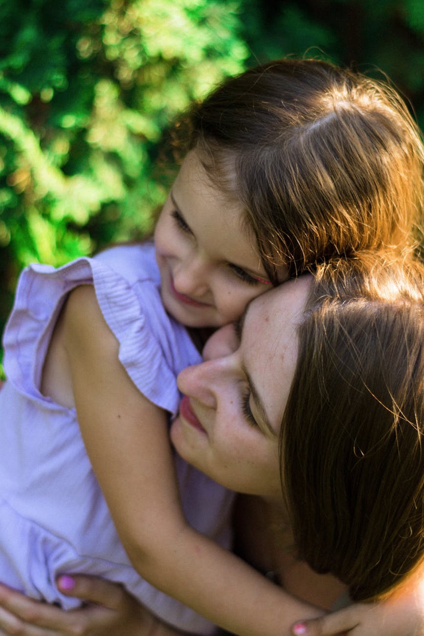 Mother and daughter sharing a warm hug in golden sunlight